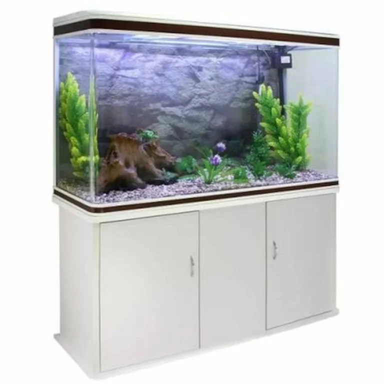 Large rectangular glass aquarium on a white cabinet stand, filled with water, rocks, driftwood, and green plants for decor and fish habitat.