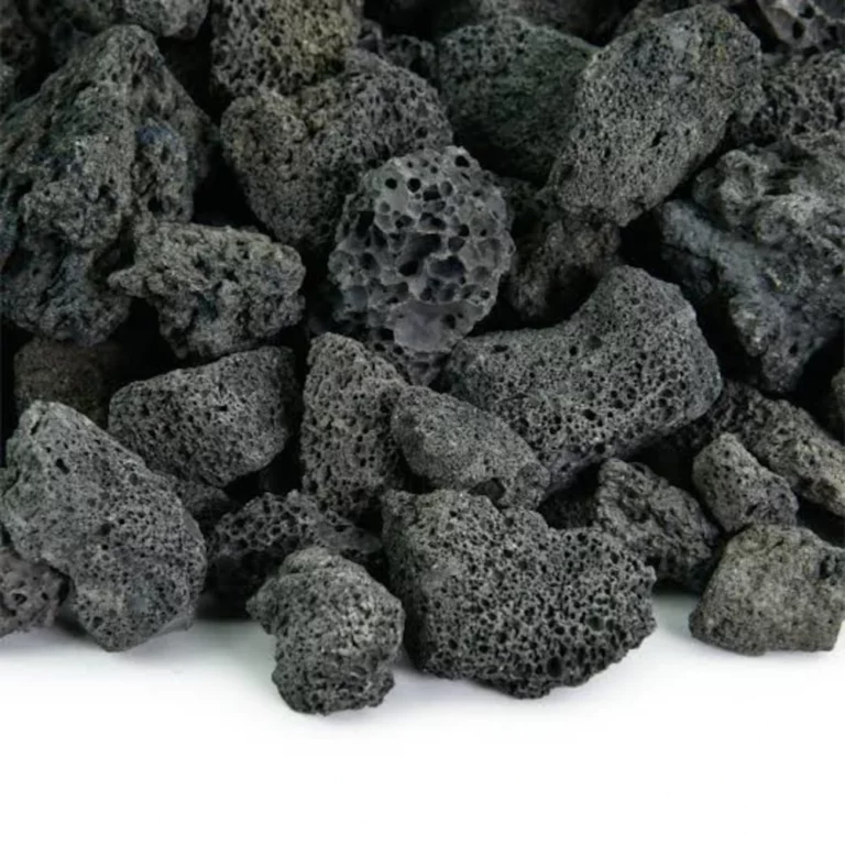 Dark, porous volcanic lava rocks piled together on a white surface.